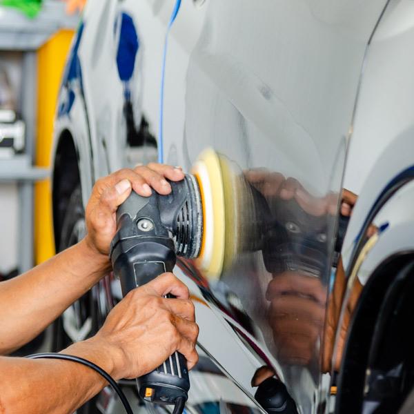 mechanic buffing out the side of a car